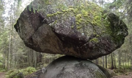 This giant boulder naturally balancing itself on top of a smaller rock in a Finnish forest