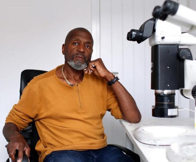 This is, Willard Wigan who specializes in creating astonishingly detailed micro-sculptures, often smaller than the eye of a needle, crafted under a microscope using grains of sand, spider silk, and gold