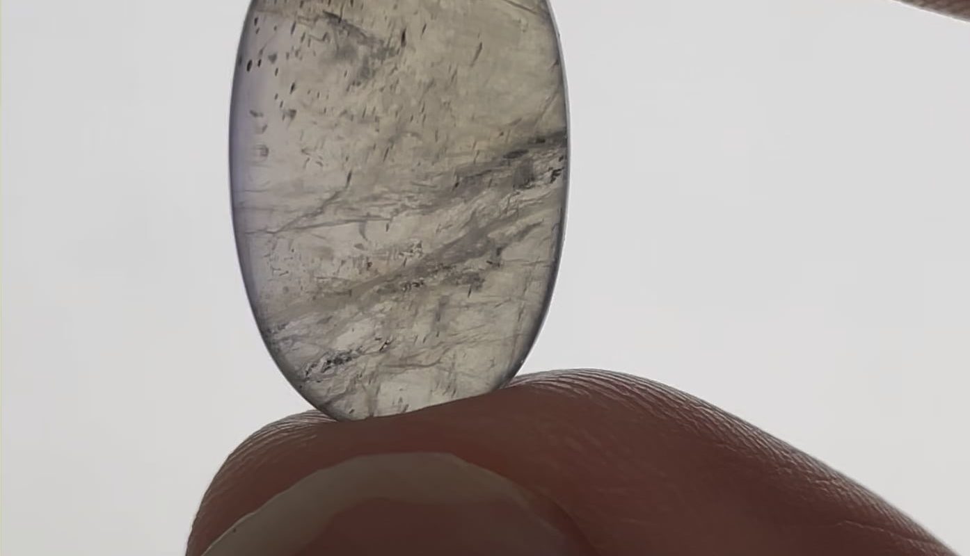 This mineral (Cordierite) changes colour when rotated due to the crystal lattice’s lack of symmetry along all 3 axes (Pleochroism)