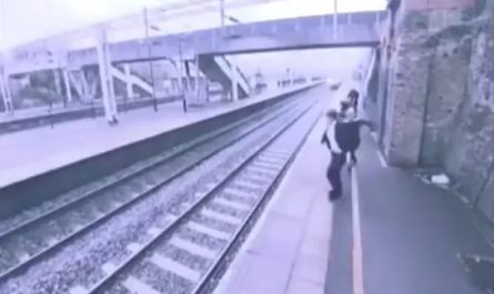 This woman runs behind a man and saves him just before he was about to leap