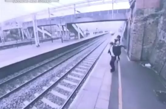 This woman runs behind a man and saves him just before he was about to leap