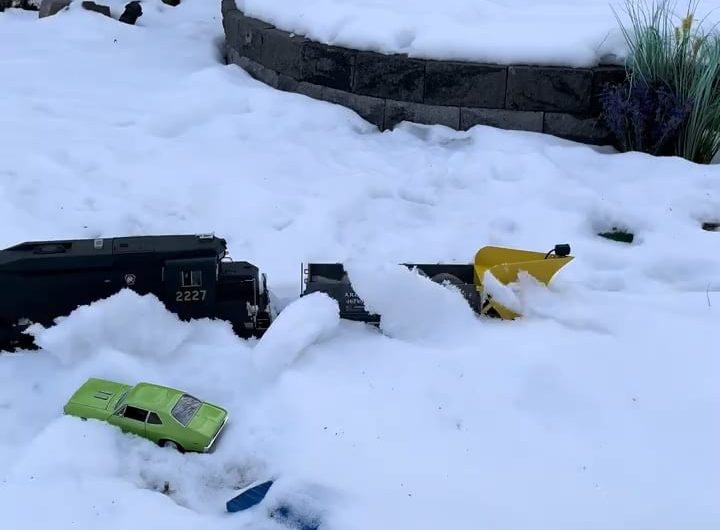 Toy train plowing the snow from its tracks