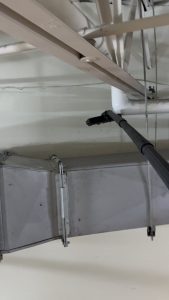 Vacuuming five years of dust off of AC ductwork.