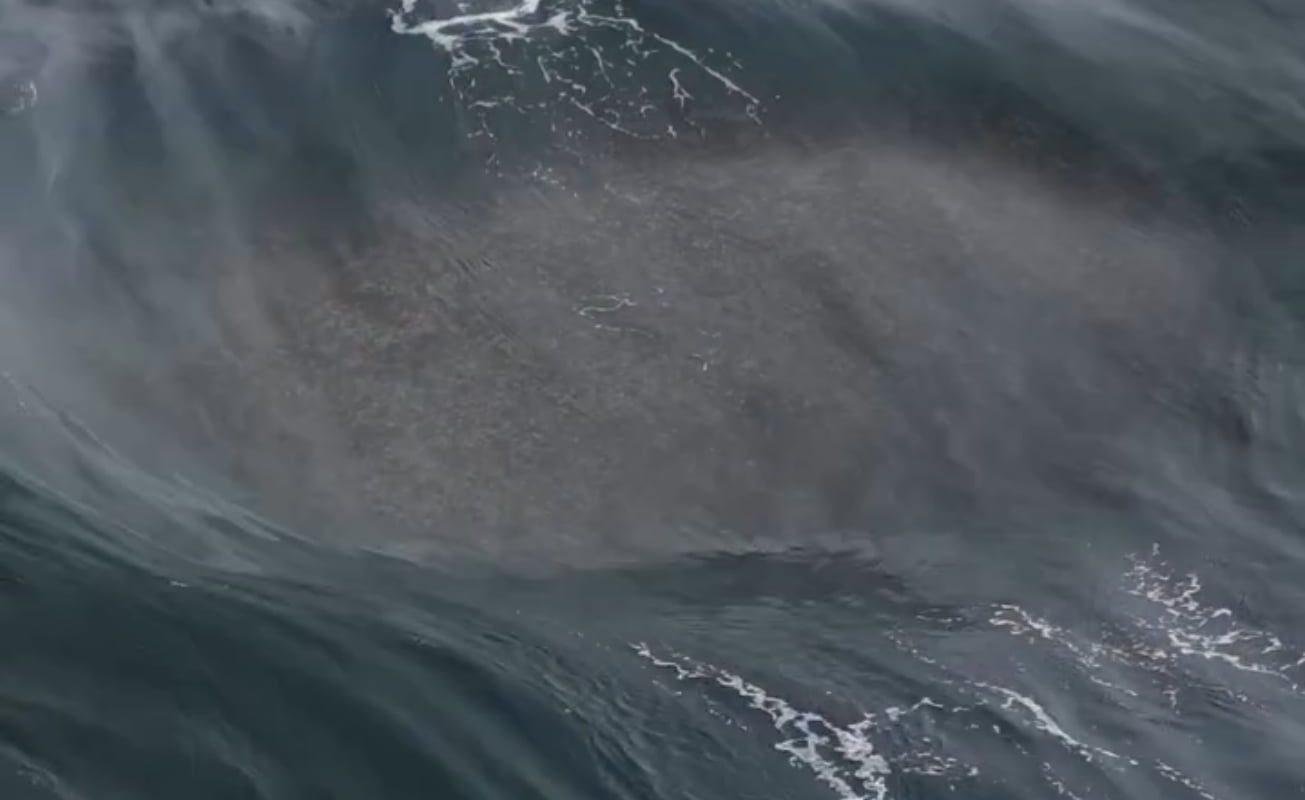 A powerful wave uprising due to small waves colliding to a big rock under water