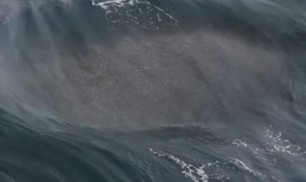 A powerful wave uprising due to small waves colliding to a big rock under water