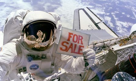 Astronaut Dale A. Gardner holds up a "For Sale" sign as a joke, pretending to offer up two failed satellites, Palapa B-2 and Westar 6, which were retrieved in space during the shuttle Discovery's STS-51A mission in 1984. Astronaut Joseph P. Allen IV can be seen reflected in Gardner's helmet visor.