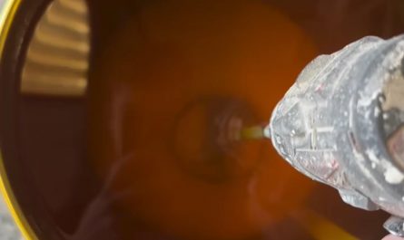 Stirring a drum of wood lacquer that’s been sitting for a while