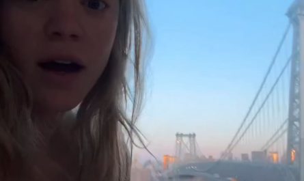 Young lady captures a full moon over the Williamsburg bridge
