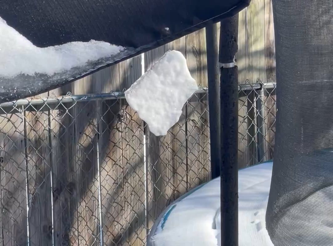 a sheet of snow spinning by a thread on my outdoor umbrella