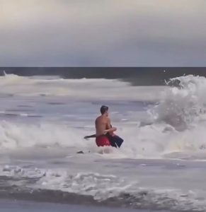 A lifeguard battled massive waves on a California beach to save a young boy caught in a rip current