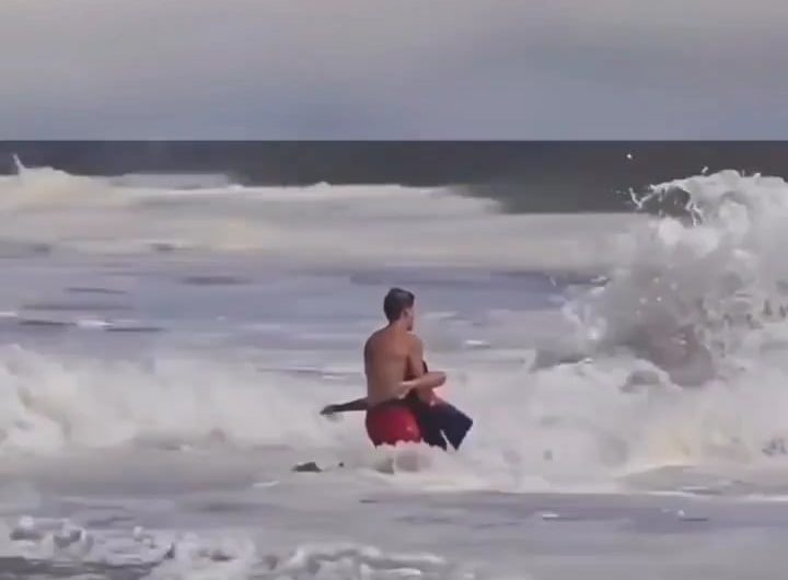 A lifeguard battled massive waves on a California beach to save a young boy caught in a rip current