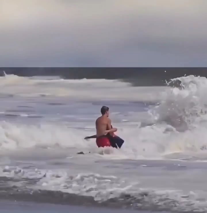 A lifeguard battled massive waves on a California beach to save a young boy caught in a rip current