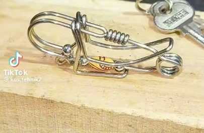 A skilled craftsman hand bends steel wire into a fully functional spring loaded keychain clip