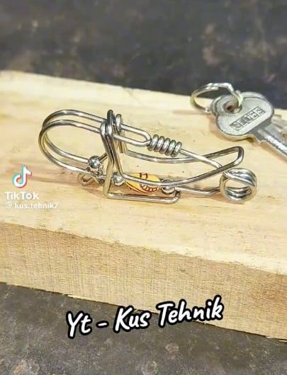 A skilled craftsman hand bends steel wire into a fully functional spring loaded keychain clip