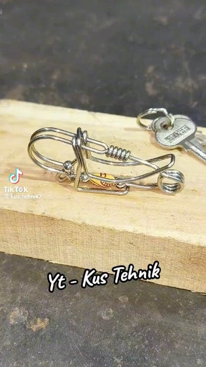 A skilled craftsman hand bends steel wire into a fully functional spring loaded keychain clip