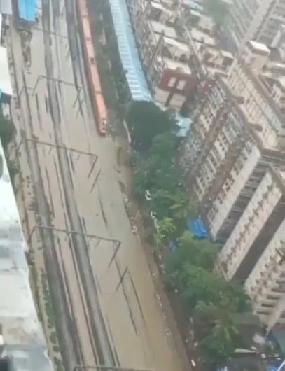 A train plowing through the flooded tracks