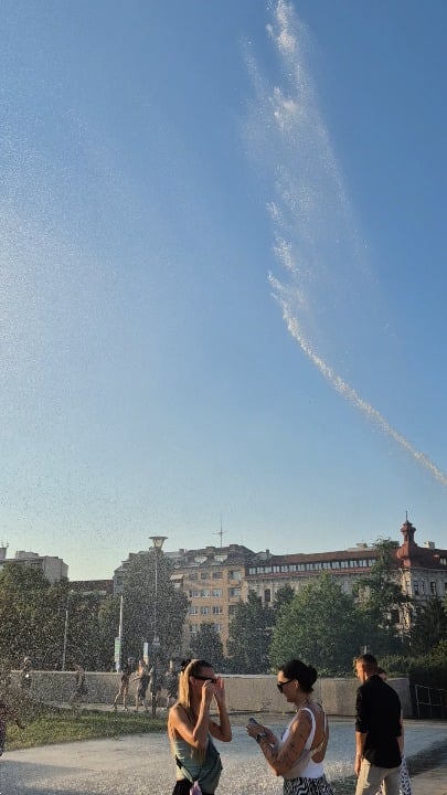 Czech firemen cooling down people at an outdoor event in Brno