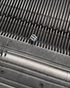 Dice stuck on the top step of an escalator
