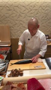 Japanese chef preparing Saba (mackarel) attentively before the next step