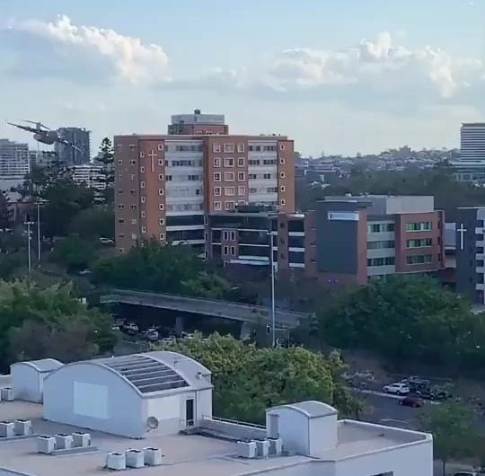 RAAF C-17 maneuvering at low altitude over Brisbane.