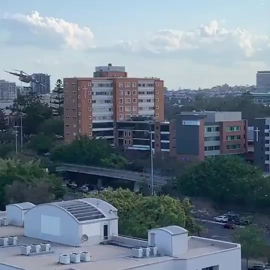 RAAF C-17 maneuvering at low altitude over Brisbane.