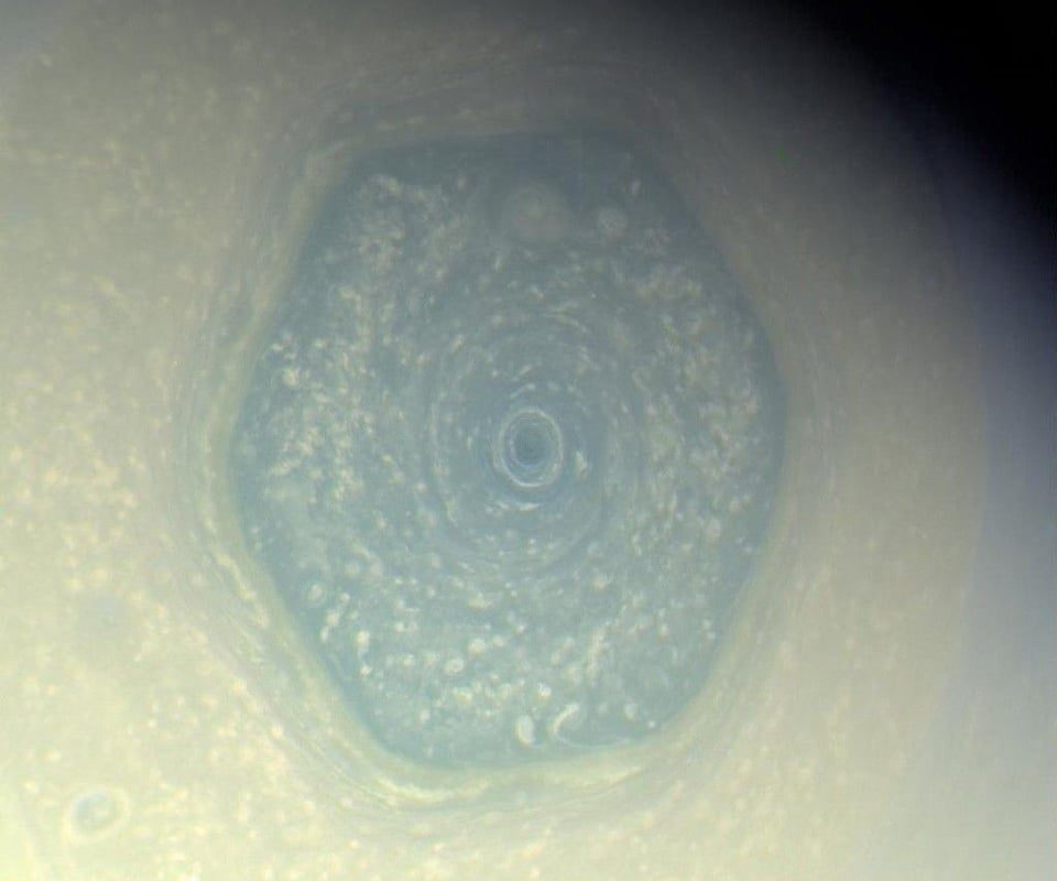 Saturn's north pole is home to a giant hexagonal storm about 30,000 km (18,600 miles) wide—large enough for more than two Earths to fit inside. First spotted in 1980, it's still raging today.