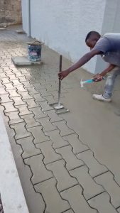 Stamping a paver pattern into wet concrete.