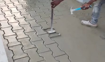 Stamping a paver pattern into wet concrete.