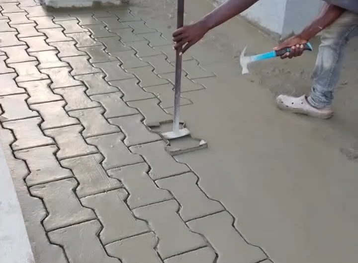 Stamping a paver pattern into wet concrete.