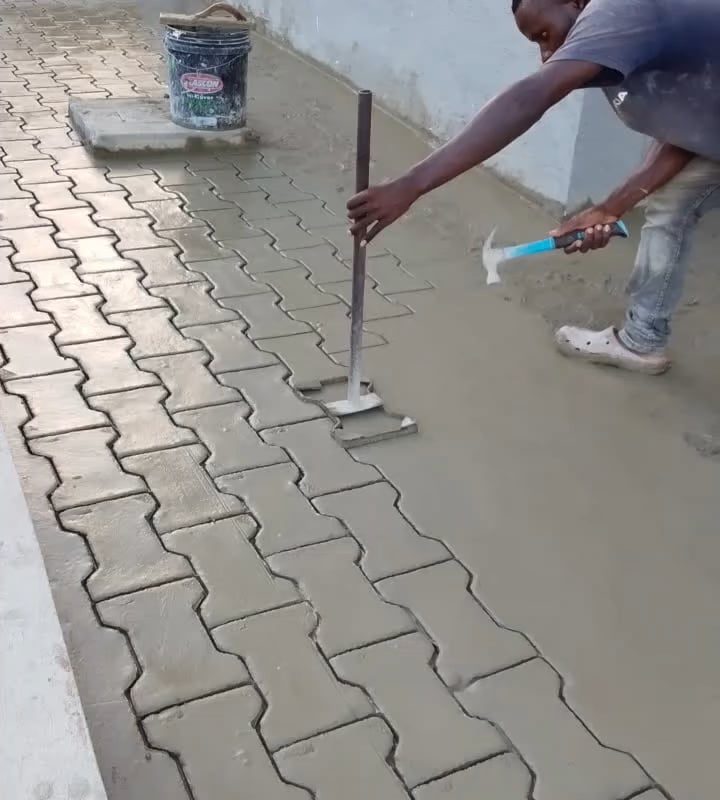 Stamping a paver pattern into wet concrete.