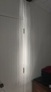 Sunset reflections off a lake through barely opened drapes