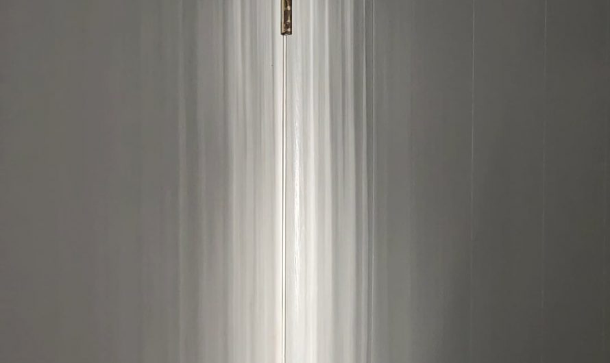 Sunset reflections off a lake through barely opened drapes