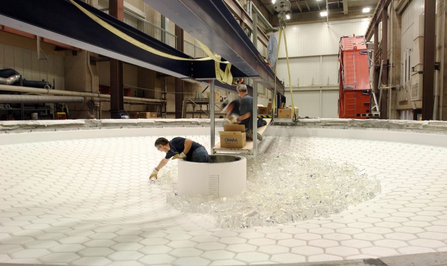 Technicians loading 51,900 pounds of glass into a furnace mold to make a giant telescope