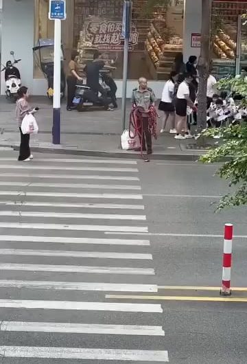 The absolute logistics of crossing the street with toddlers in Asia. They even bring out a safety rope for 20 kids.