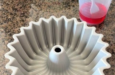 The process of carefully layering and then cleanly unmolding a rainbow jelly cake