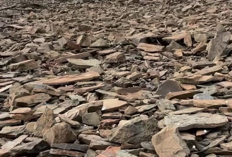 The sound of hail falling on a mountainside covered in slate rock