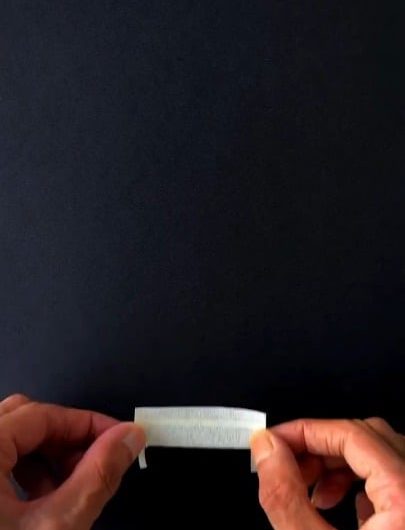 The way chalk and pastels are smudged on black paper to create light rays above a bench