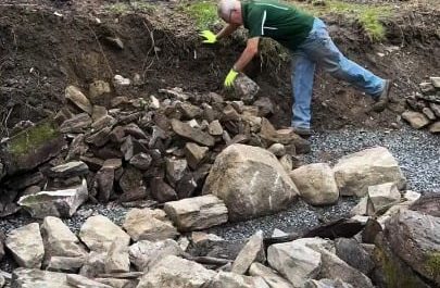This guy builds a dry lay, fieldstone/flagstone retaining wall with steps