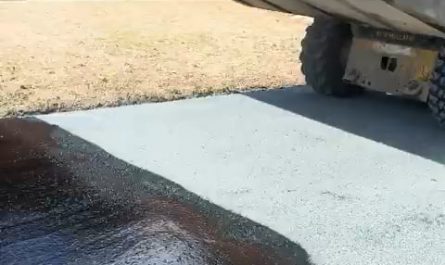 This skid steer laying down chipped rock