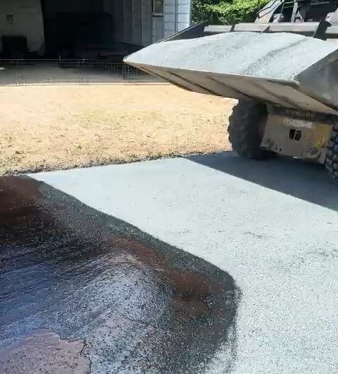 This skid steer laying down chipped rock