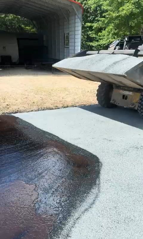 This skid steer laying down chipped rock