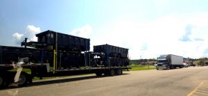 Truck pulling a trailer with two trailers on the trailer and a trailer on top of each trailer on the trailer being pulled by the truck.