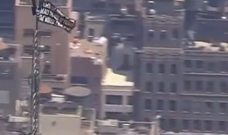 Two climbers have scaled the Empire State Building and unfurled a banner from the top of the spire