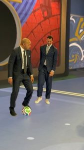 Two football legends casually showing off their skills in a suit and tie