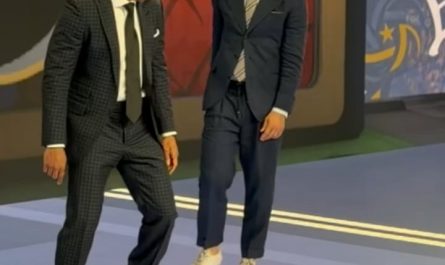 Two football legends casually showing off their skills in a suit and tie