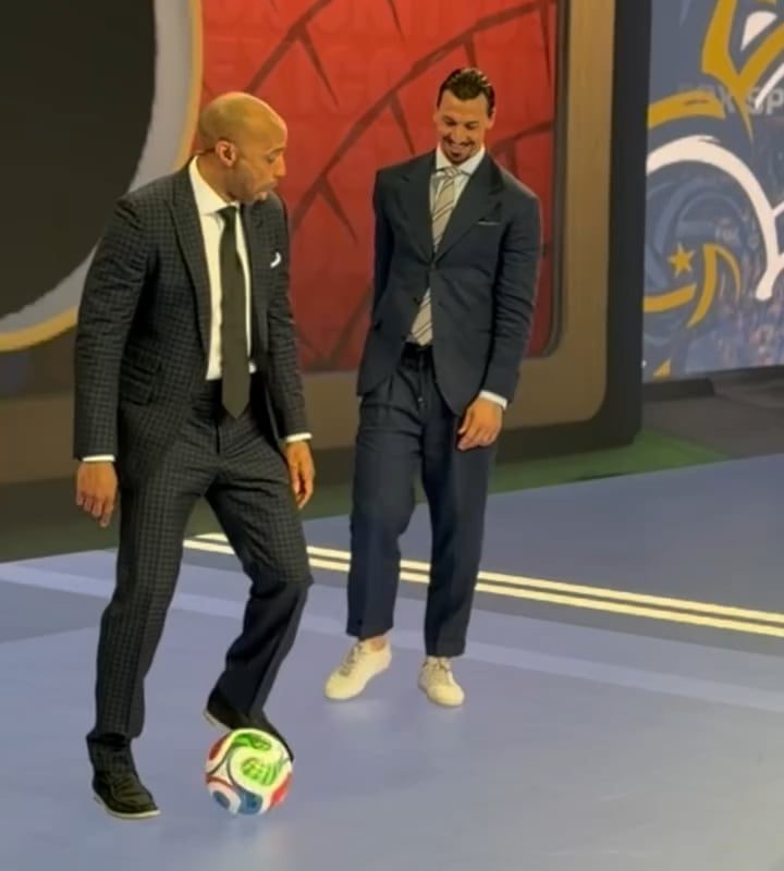 Two football legends casually showing off their skills in a suit and tie