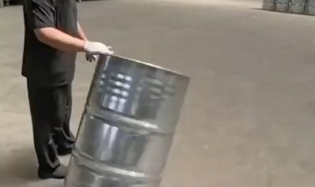 Warehouse worker rolls barrels to perfection
