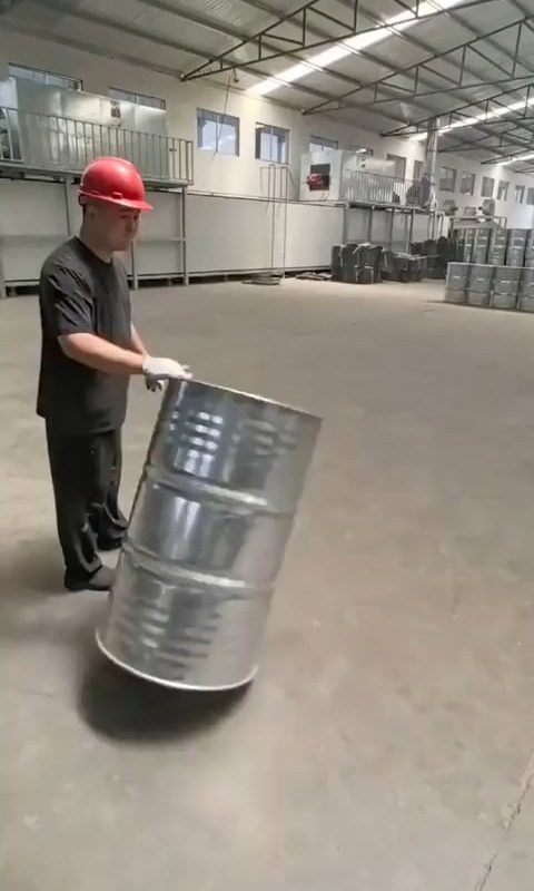 Warehouse worker rolls barrels to perfection