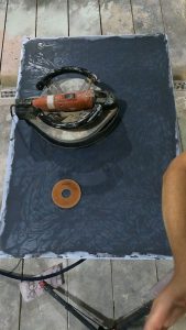 Wet grinding a concrete table top to expose and polish an intricate inlay - OC