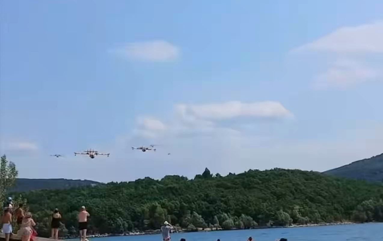 Astonished beachgoers at the Lac de Sainte Croix film five French Canadair CL-415 firefighting planes scooping up water in quick succession to fight the wildfires in southern France.